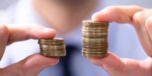 Mann vergleicht zwei Münzstapel