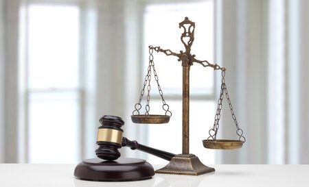Judges gavel and scale of justice on a white table